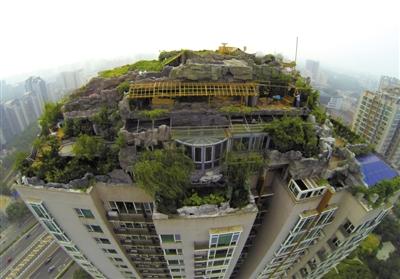 　　昨日，身穿橘黃色馬甲的工作人員在人濟(jì)山莊樓頂拆除違章建筑。新京報記者 吳江 攝