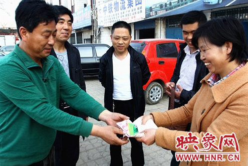 好的哥馬文學（左一）將現(xiàn)金及銀行卡還給失主