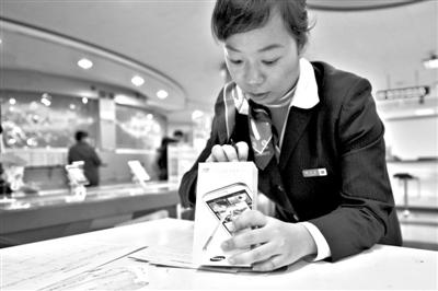 11月6日，北京移動西直門營業(yè)廳的工作人員在為顧客購買的4G手機(jī)登記。新華社發(fā)