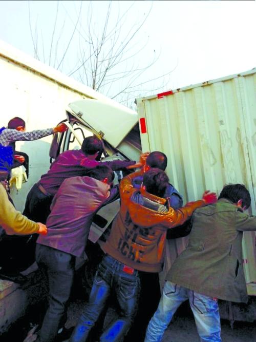 眾人把車(chē)往后推，從駕駛室救人