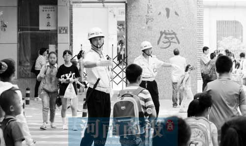 伊河路小學(xué)門口，兩名巡防隊員護送學(xué)生過馬路