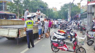 路旁的非機(jī)動(dòng)車(chē)道已被多輛違法停放的電動(dòng)車(chē)和自行車(chē)占滿