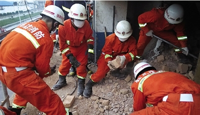 消防人員在清理熔鹽爐倒塌的廢墟。