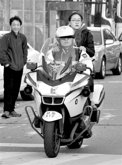 7日，首爾，警察將一名考生送抵考場。新華社發(fā)