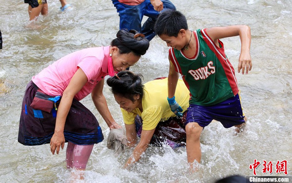 7月9日，村民在小河里摸魚搶魚。譚凱興 攝