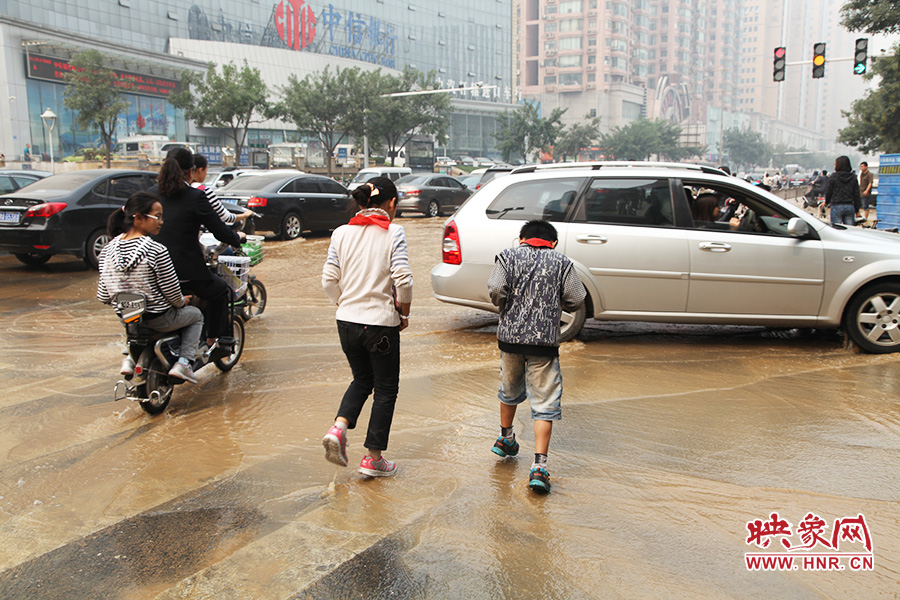 放學(xué)路過的學(xué)生在路口玩水嬉戲 放學(xué)路過的學(xué)生在路口玩水嬉戲