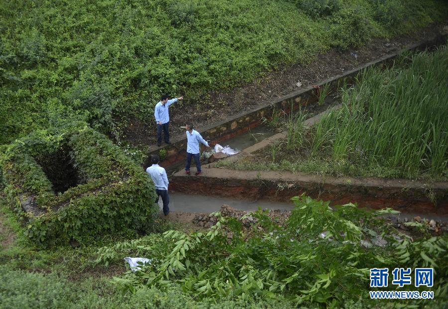 5月18日，工作人員在槽罐車泄漏現(xiàn)場(chǎng)附近的水渠邊查看情況。