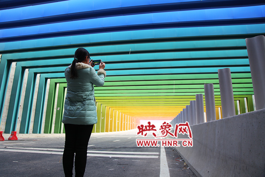 一女孩拿出手機(jī)拍照。