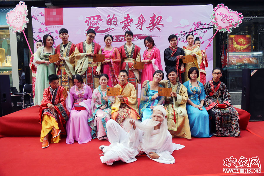 現(xiàn)場8對兒年輕男女舉起“賣身契”集體拍照。