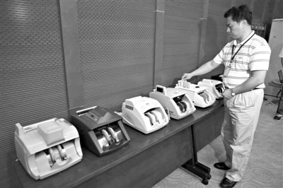 昨日，央行工作人員用各種驗(yàn)鈔機(jī)對C1F9假幣進(jìn)行測試，機(jī)器均能及時(shí)作出異常報(bào)警反應(yīng)。新京報(bào)記者 浦