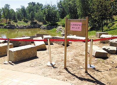 圓明園規(guī)月橋橋體構(gòu)件區(qū)域的警戒線和提示牌。 新京報記者 鄧琦 攝