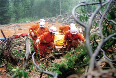 昨日，消防隊(duì)員在四川省都江堰市中興鎮(zhèn)三溪村滑坡現(xiàn)場運(yùn)送遇難者遺體。新華社記者 薛玉斌 攝