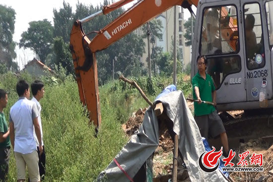 陳寶成手持自制刀斧守在挖掘機旁阻止便衣民警靠前。駕駛室內(nèi)，張朋珂正向受害人郭曉剛身上澆汽油。（視頻截圖）