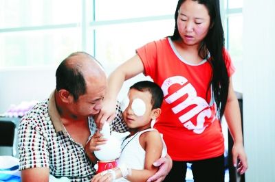 斌斌手術后第一天恢復良好，斌斌父母在用玩具逗他開心供圖/嚴益
