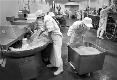 昨日，位于順義李遂開發(fā)區(qū)的慶豐包子鋪配送中心生產車間，工人們正在斬拌胡蘿卜餡料。