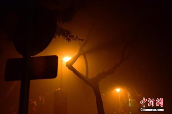 1月31日凌晨，市民行走在煙霧繚繞的南京街頭。當(dāng)天是農(nóng)歷馬年正月初一，南京有限開禁燃放煙花爆竹正逢下霧天，空氣的不流通致使煙花爆竹燃燒后產(chǎn)生的顆粒物不能及時(shí)散開，造成整座城市煙霧繚繞。據(jù)當(dāng)?shù)丨h(huán)保部門發(fā)布的信息顯示，空氣質(zhì)量屬重度污染。中新社發(fā) 泱波 攝