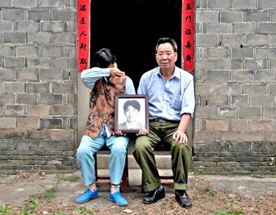 江蘇鎮(zhèn)江，老劉夫婦捧著獨(dú)生子的遺像在老家前留影南方都市報(bào)供圖L