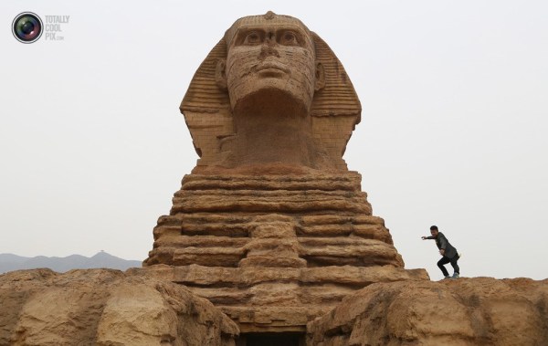 石家莊郊外，一名男子與山寨版獅身人面像合影留念。