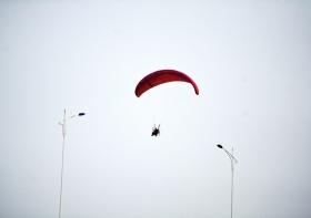 10月25日下午，動(dòng)力傘從一對(duì)路燈上空飛過(guò)