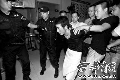 犯罪嫌疑人韓牙某圍著圍裙在廚房?jī)?nèi)拉面，被民警抓獲 本報(bào)記者 鄧小衛(wèi) 攝