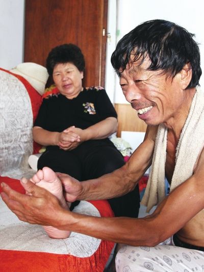 慈成富為老伴按摩。