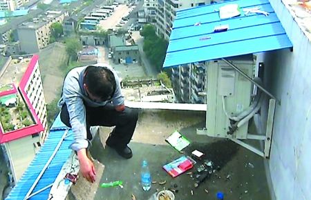 男子蹲在陽臺(tái)邊上