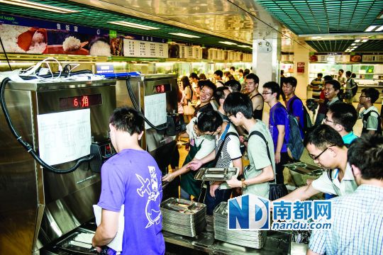 昨日，華南理工大學(xué)一食堂內(nèi)，學(xué)生們正在使用新安裝的自動(dòng)打飯機(jī)打飯。中新社發(fā)