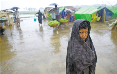5月14日，緬甸若開邦實(shí)兌難民營，羅興亞族難民在雨中行走。熱帶風(fēng)暴“馬哈森”即將登陸緬甸，這里的難民開始乘船撤離。
