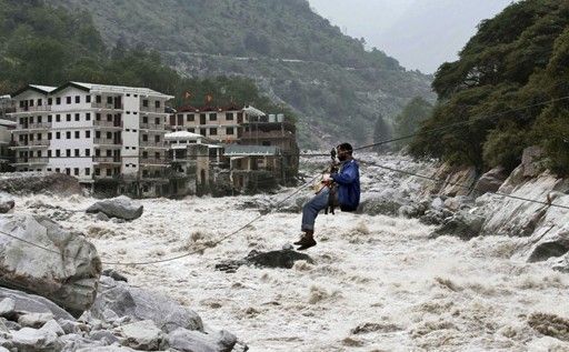 一名印度男子靠繩索渡河。