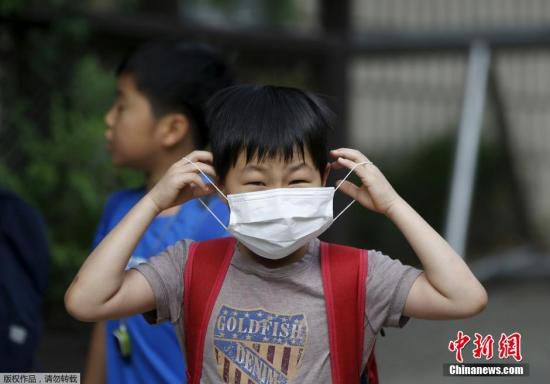 圖為當(dāng)?shù)貢r間2015年6月8日，韓國未停課的學(xué)校，學(xué)生課前戴口罩測體溫。