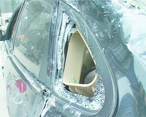 爆炸導(dǎo)致部分窗玻璃碎裂掉落,殃及樓下停放的轎車。