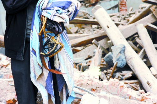 老人手中拿著曾控制住他的電線、床單