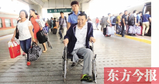 李剛手術(shù)后歸來，在車站工作人員幫助下走出鄭州火車站站臺  東方今報(bào)首席記者 張曉冬 攝