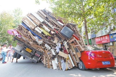 紅色小轎車被砸，卡在路邊動彈不得。