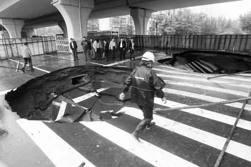 中原路西三環(huán)立交橋下由南向北原本4個(gè)車道，由于塌坑，而今3個(gè)車道被圍擋