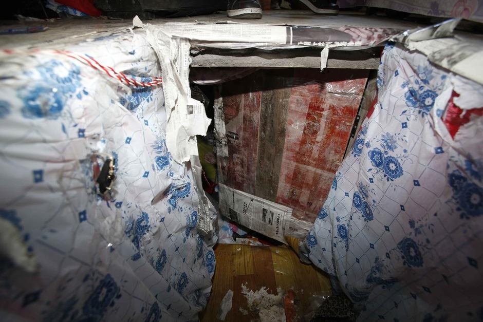 陳小龍在出租屋外，自行又圍起一堵圍墻，安裝了一個門。圍墻上都是豎起的鐵釘，外面堆著土，鄰居猜是從地底挖出來的。洞口就在床邊，0.5米見方，深約1.5米。洞口表面一塊紙板掩蓋，打開紙板跳入洞底，是一扇小木門，木門外有插銷，可以從外面鎖上。