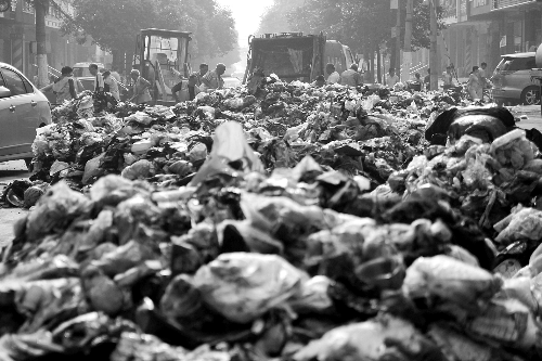 垃圾堆滿整個路口，環(huán)衛(wèi)工人們正在清理