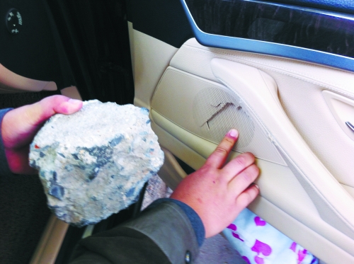 “飛”進寶馬車內(nèi)的大石塊,將寶馬車的車門內(nèi)飾板砸爛。