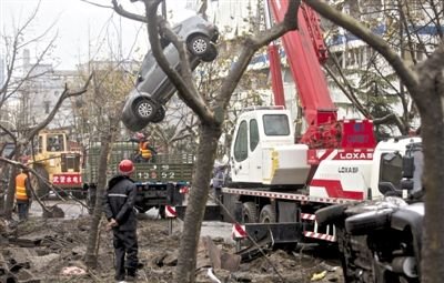 輸油管道爆炸后，搶修人員將被炸毀的車輛運出現(xiàn)場。