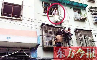 施救現(xiàn)場，劉鵬（圈內(nèi)）先用繩子捆住老太確保安全 勞動報(bào)記者 郭娜 供圖