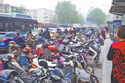 省人民醫(yī)院北門，路邊的公交站牌處停滿非機(jī)動(dòng)車，上、下客只能在快車道上。