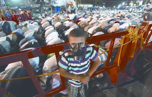 當(dāng)?shù)貢r(shí)間28日晚，在埃及開(kāi)羅納賽爾城，一名小男孩頭戴防毒面具參加穆兄會(huì)的集會(huì)示威。