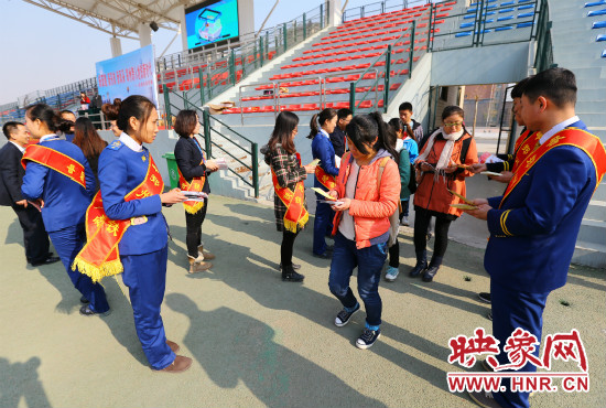 活動(dòng)現(xiàn)場工作人員給同學(xué)們發(fā)放宣傳冊(cè)、環(huán)保袋。