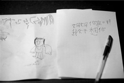 名叫袁明燕的小姑娘用筆在紙上不斷寫“媽媽”二字。