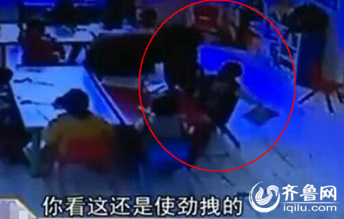 孩子上課時(shí)被老師拖拽。（紅圈中拿書者系孩子）