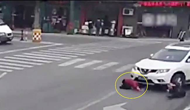 圖為小姑娘被卷進車輪下瞬間。