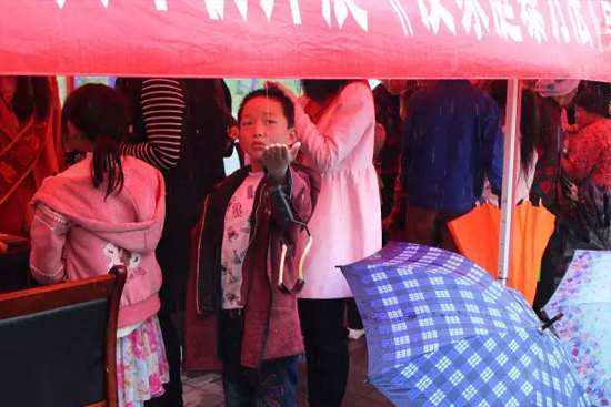 因為雨下的太大，小男孩玩起了接水游戲。