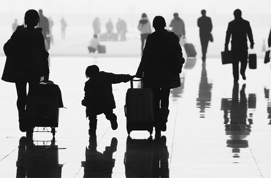 昨日，鄭州東站，一名孩子拉著媽媽和包裹快樂地奔走在春運(yùn)的途中