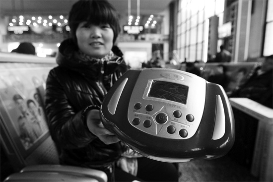 火車站候車室，李女士向記者展示她準(zhǔn)備孝敬父母的按摩儀