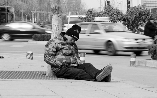 2月2日，鄭州市中州大道農(nóng)業(yè)路立交橋下，50歲的王文德打算在臨近春節(jié)前再接些零活兒，由于疲憊，他睡著